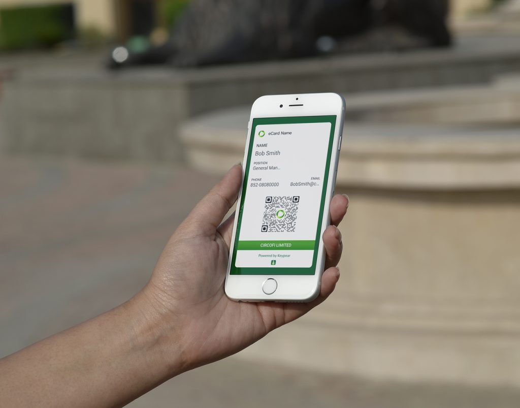 Photo depicting a KeyConnects business card on a phone being held by a user